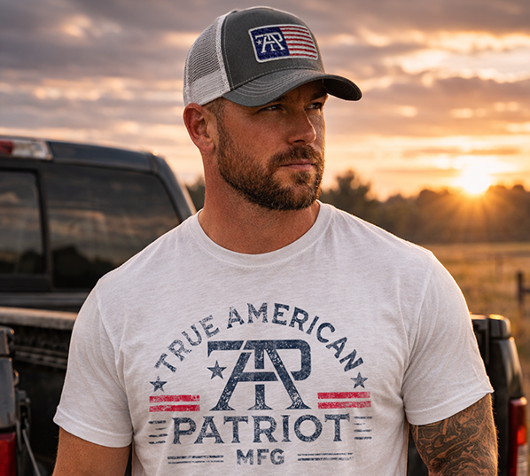 Zoom of man wearing True American Patriot MFG Flag Patch Hat and Brand Tee with sunset and truck in background