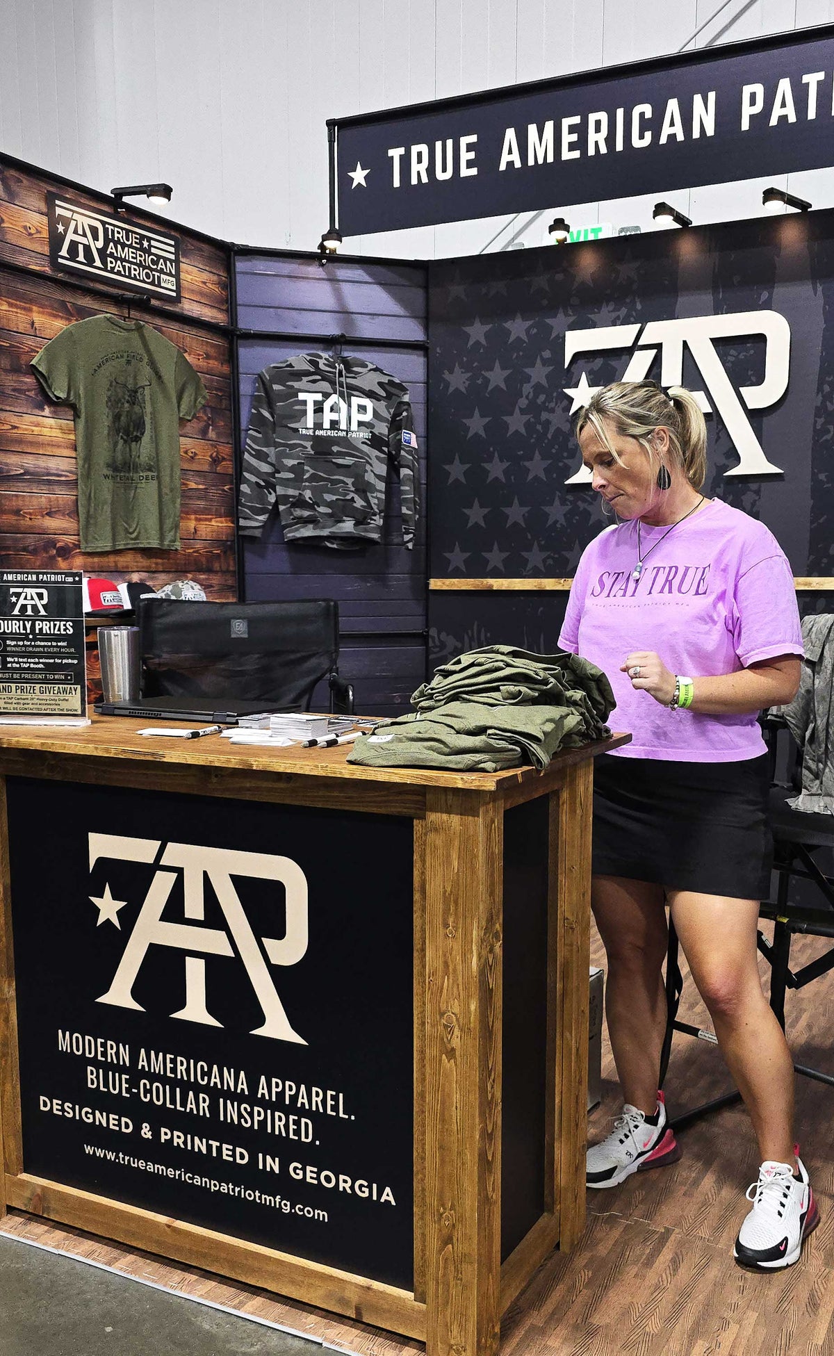 TAP team member organizing shirts at the Georgia Buckarama booth