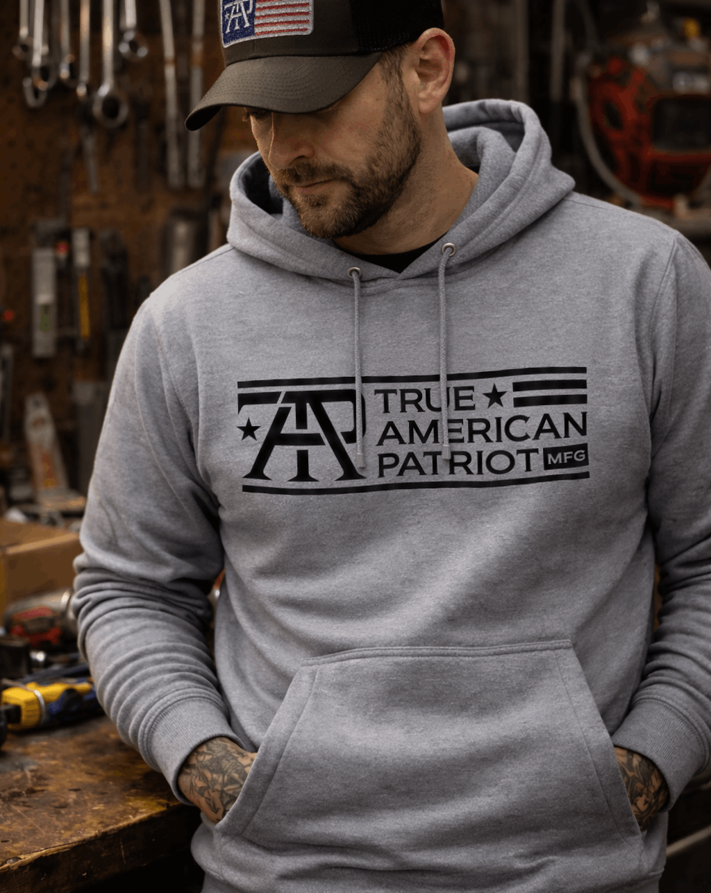 Man in workshop wearing a True American Patriot Mfg Classic Logo Hoodie