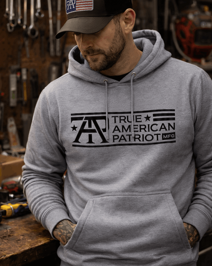 Man in workshop wearing a True American Patriot Mfg Classic Logo Hoodie