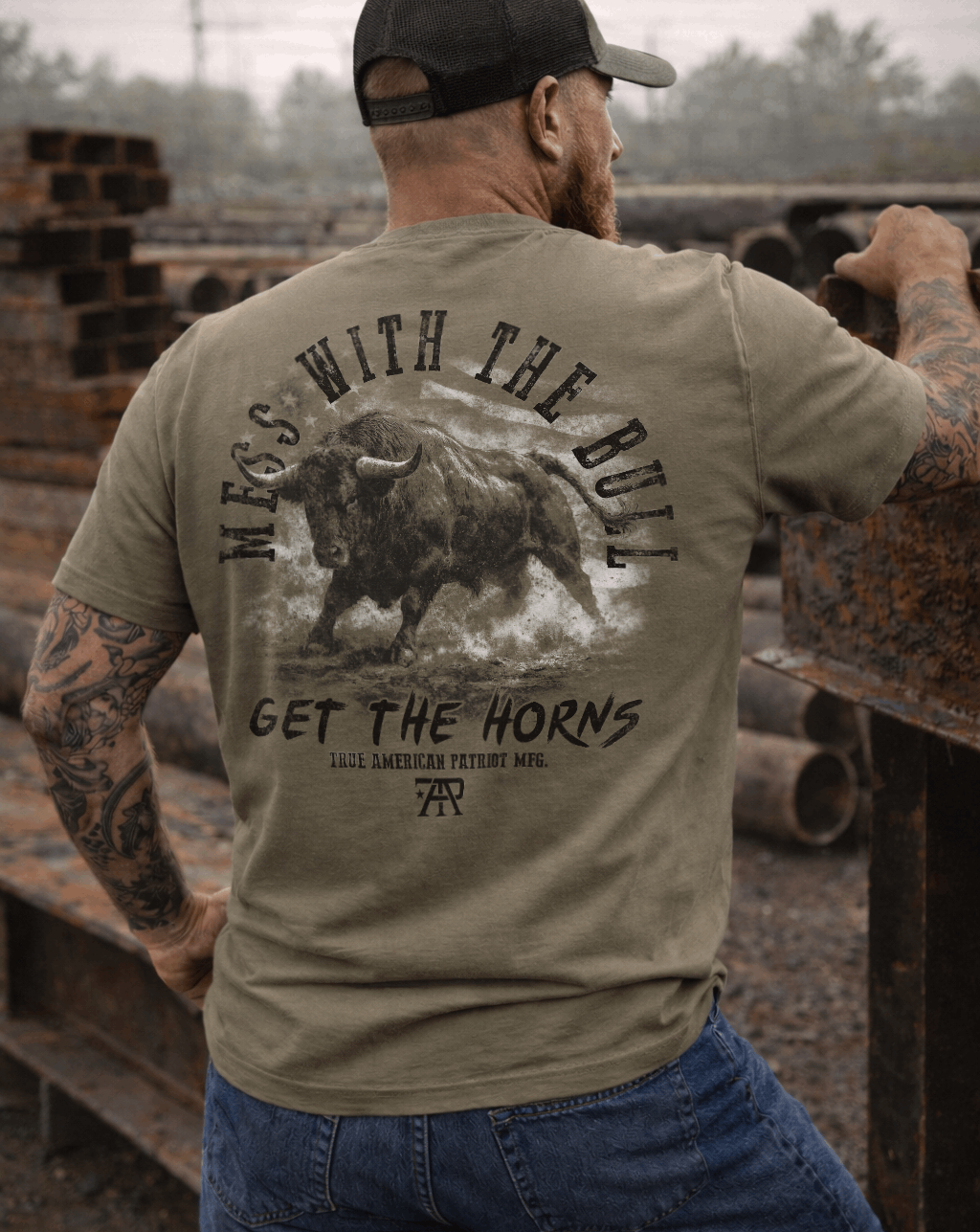 Man wearing a True American Patriot Mfg Mess With The Bull Get the Horns Tee in a steel yard