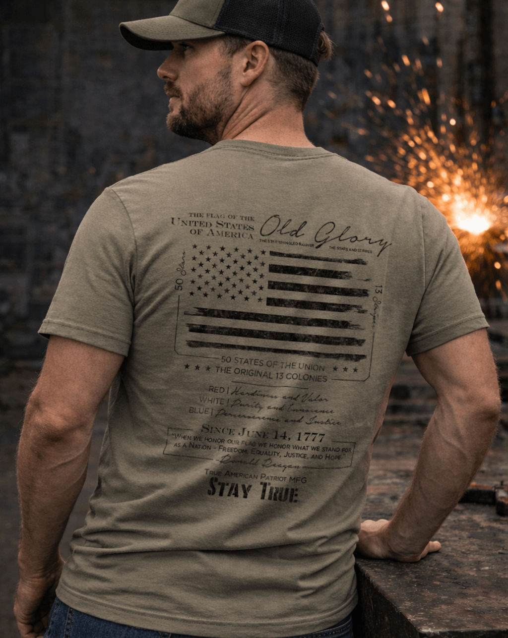 Blue Collar Man wearing a True American Patriot Mfg Old Glory Blackout Tee standing in a workshop