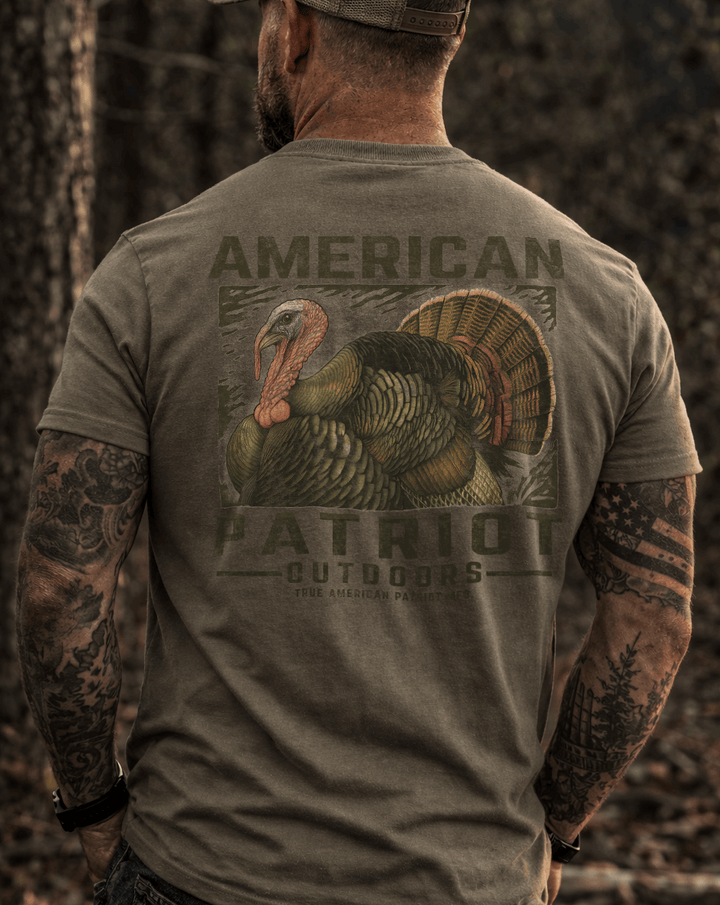 masculine person wearing a True American Patriot Mfg - Outdoors - Wild Turkey Tee standing in the woods